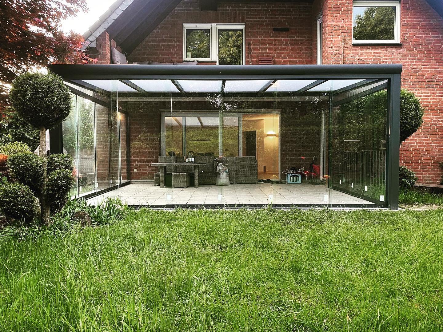 Glas-Veranda mit rahmenlosen Schiebewänden